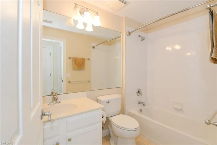 Full bathroom featuring vanity, toilet, tile patterned floors, and tiled shower / bath combo