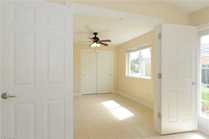Tiled empty room with ceiling fan