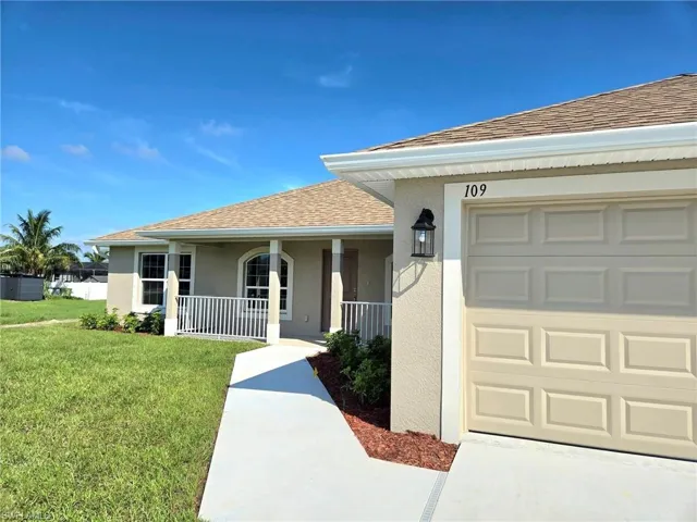 View of front of house with a porch, a front lawn, and a garage