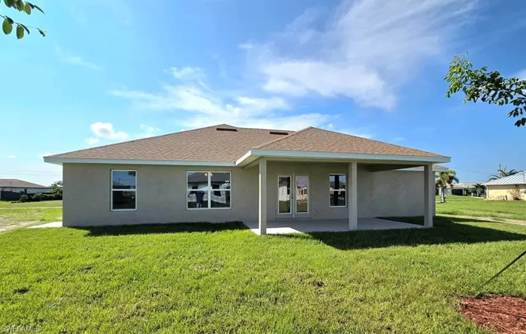 Rear view of property with a patio and a yard