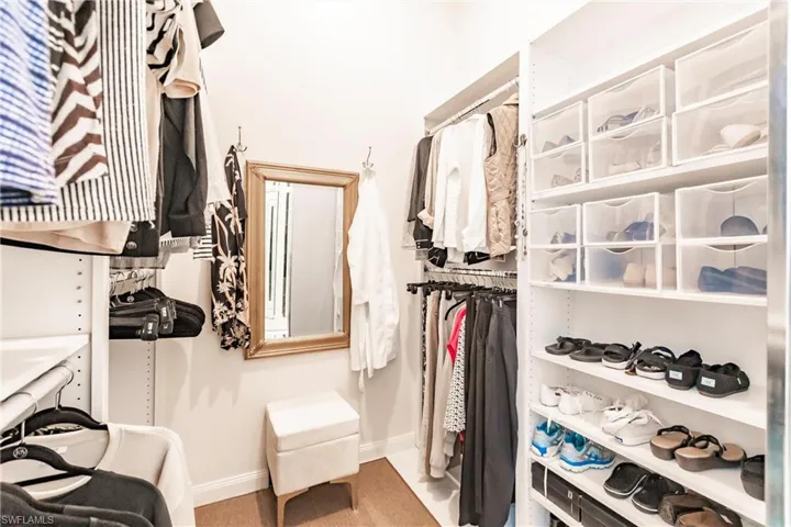 Large walk in closet has adjustable shelves and clothes rods.