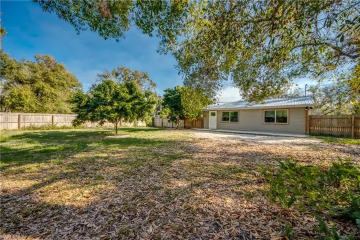 Rear view of house featuring a patio area, a metal roof, and a fenced backyard