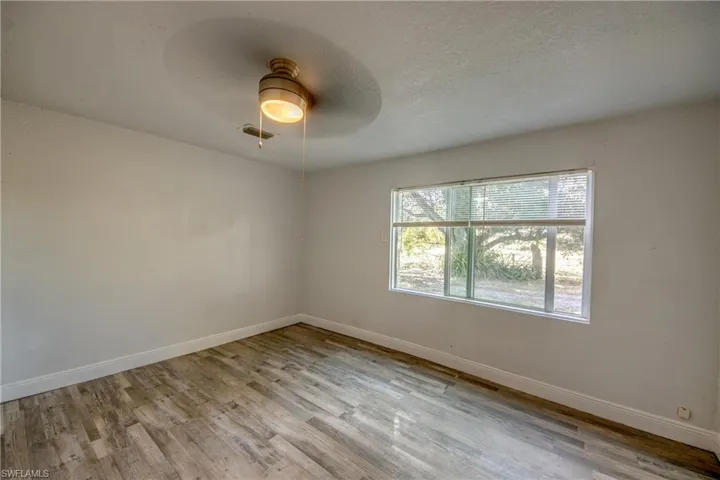 Unfurnished room featuring light wood-style flooring, a textured ceiling, and ceiling fan