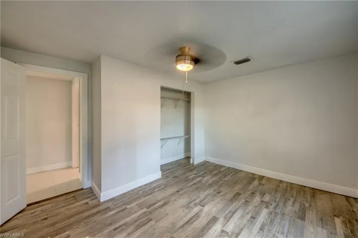Unfurnished bedroom featuring a closet, light wood finished floors, and ceiling fan