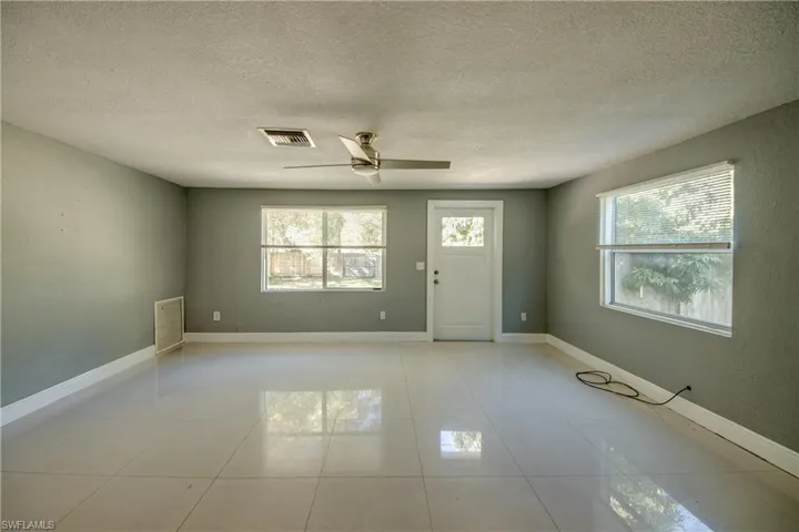 Spare room with a textured ceiling, light tile patterned floors, and a ceiling fan