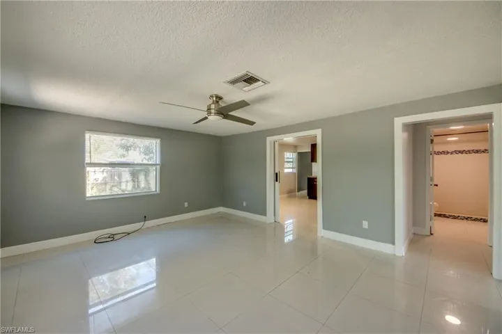 Unfurnished bedroom with a textured ceiling, a ceiling fan, and light tile patterned floors
