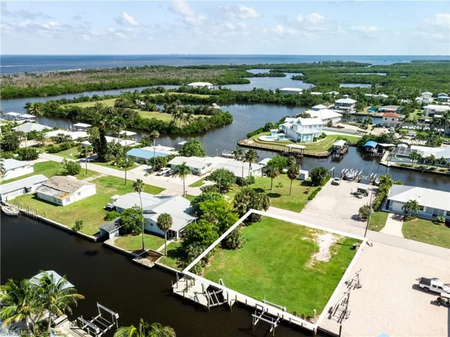 Aerial perspective of suburban area with a nearby body of water and property boundaries highlighted