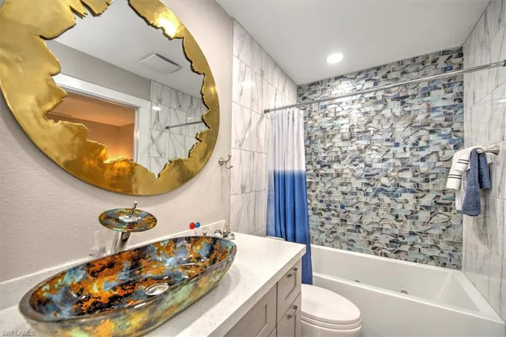 Full bathroom featuring shower / tub combo with curtain, vanity, and toilet
