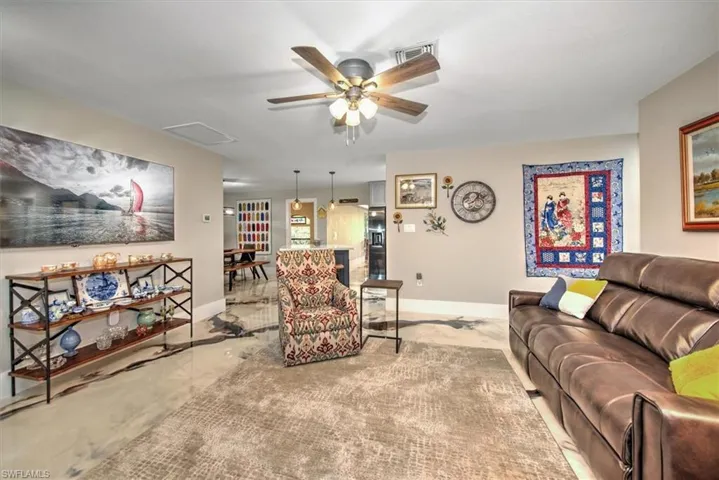 Living room featuring a ceiling fan, visible vents, and baseboards