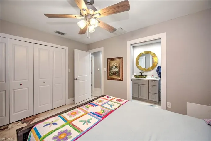 Bedroom featuring connected bathroom, visible vents, a closet, and ceiling fan