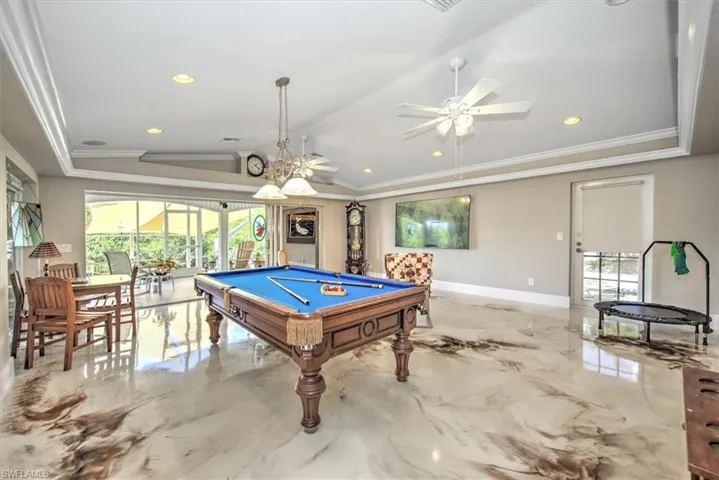 Game room featuring pool table, a ceiling fan, marble finish floor, and ornamental molding