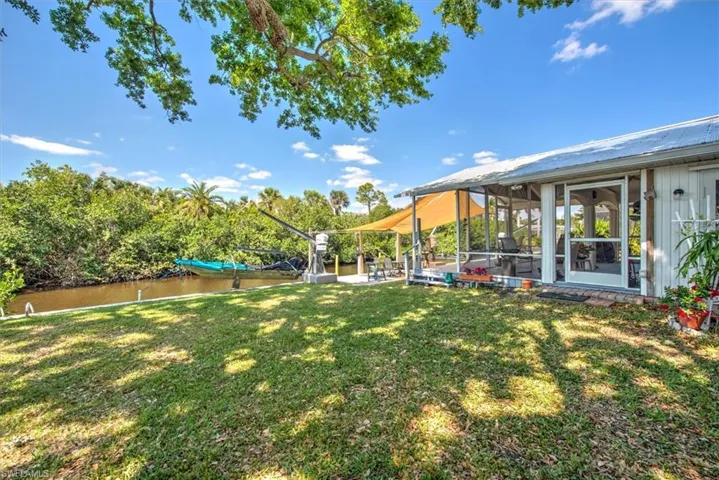 View of yard featuring a water view and a sunroom