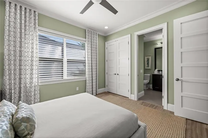 Bedroom featuring a closet, ornamental molding, ceiling fan, recessed lighting, and ensuite bath