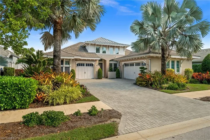 View of front of house with an attached garage, stucco siding, and decorative driveway