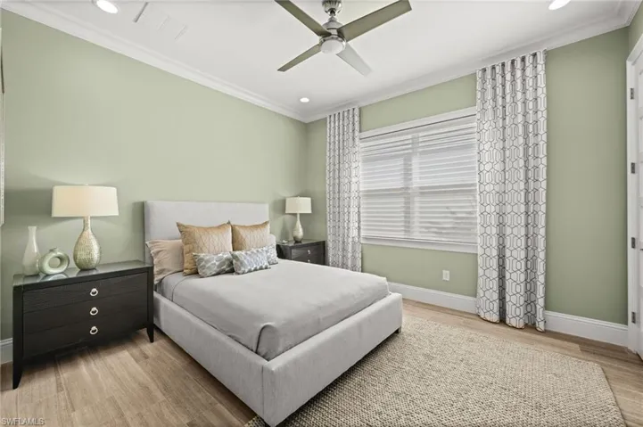 Bedroom featuring light wood-style flooring, crown molding, a ceiling fan, and recessed lighting