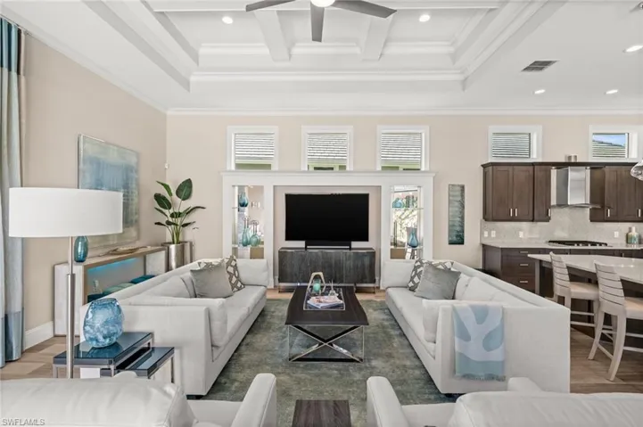Living area featuring plenty of natural light, crown molding, recessed lighting, beamed ceiling, and a ceiling fan