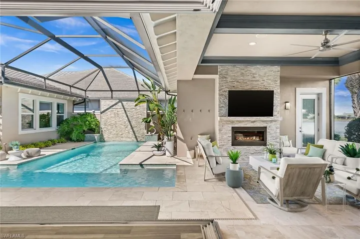 Outdoor pool with a patio area, an outdoor living space with a fireplace, a sunroom, a lanai, and ceiling fan