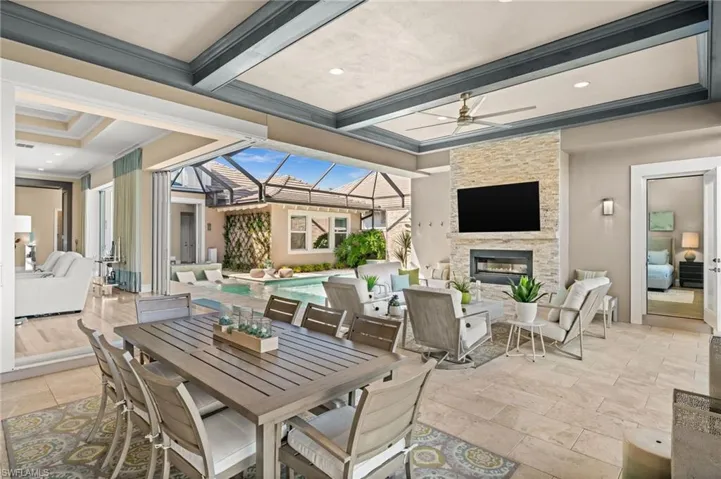 View of patio featuring glass enclosure, a ceiling fan, an outdoor pool, outdoor dining space, and a sunroom