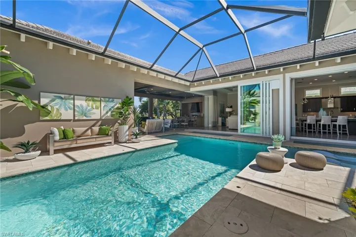 Swimming pool with a sunroom, a patio, a lanai, and an outdoor hangout area