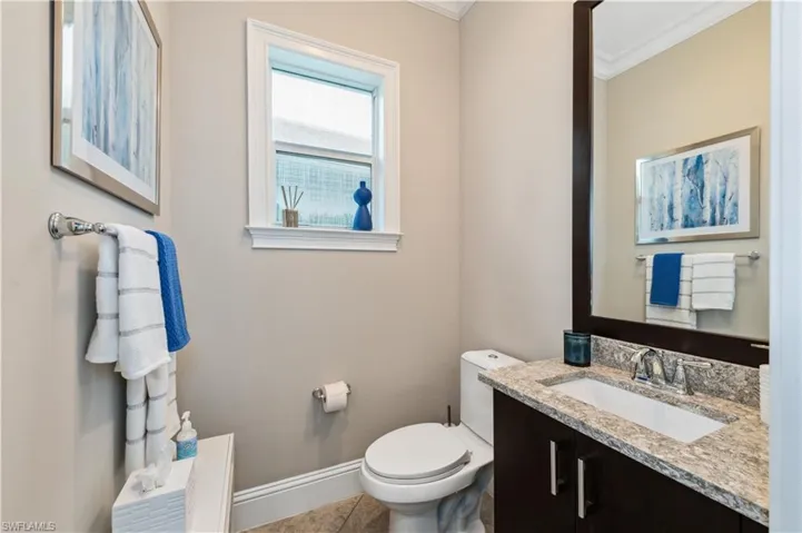 Pool Bathroom featuring vanity, tile patterned flooring, and crown molding