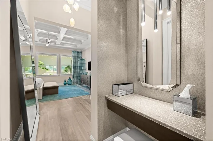 Hall featuring coffered ceiling, beamed ceiling, light wood-style flooring, and crown molding
