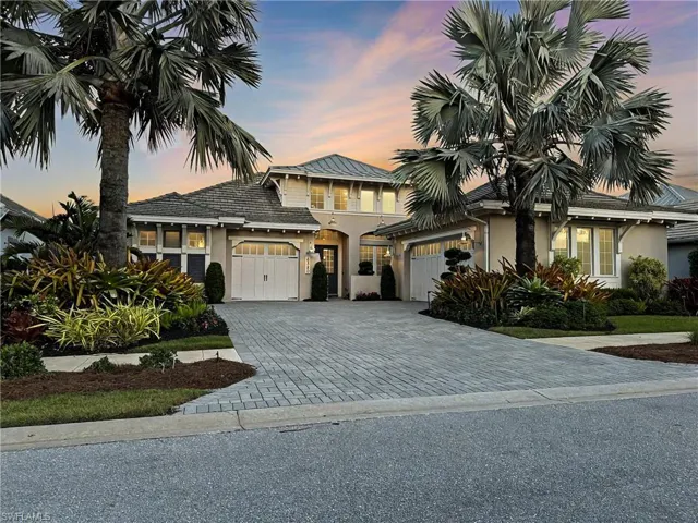 View of front facade with stucco siding, decorative driveway, and an attached garage