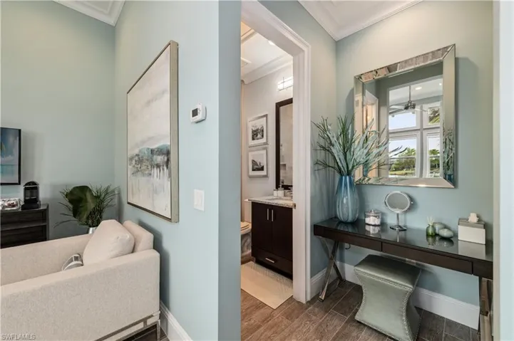 Hall with wood finish floors and ornamental molding