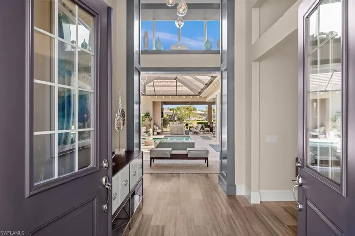 Foyer entrance featuring light wood-style flooring and a towering ceiling