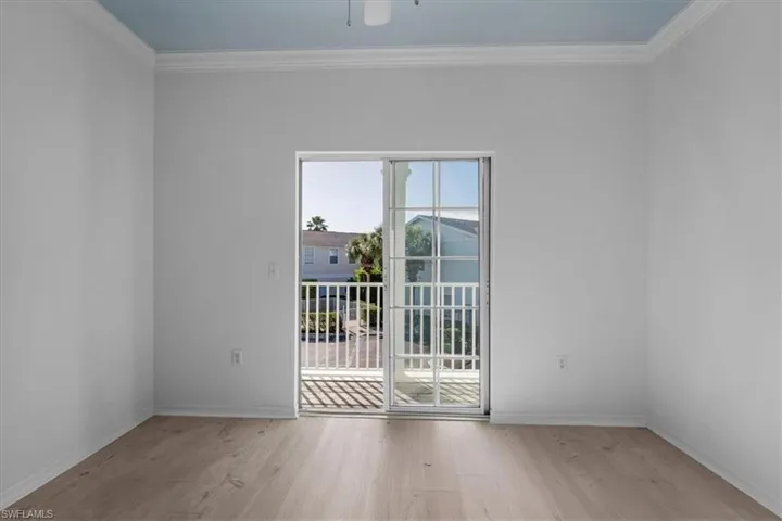 Unfurnished room with ceiling fan, light wood-type flooring, and crown molding