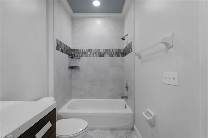 Full bathroom with vanity, toilet, and tiled shower / bath
