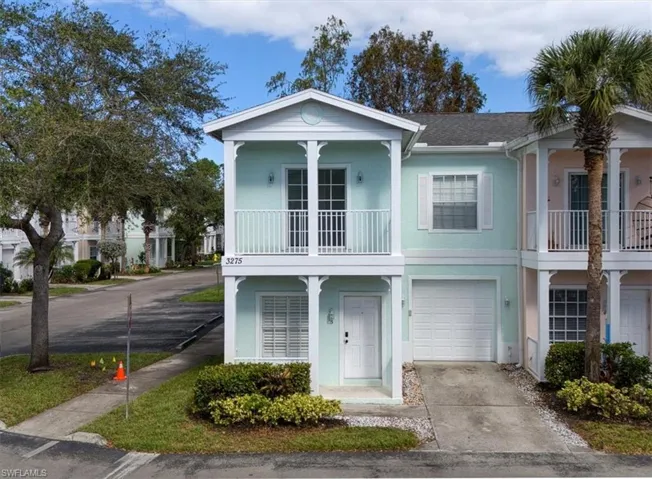 View of front of property featuring a balcony and a garage