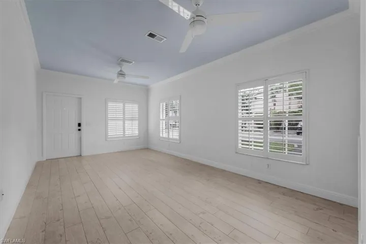 Living room with a wealth of natural light, ceiling fan, and light hardwood / wood-style floors