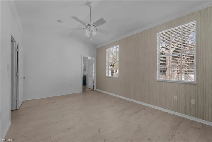 Primary Bedroom featuring plenty of natural light, light hardwood / wood-style floors, ceiling fan, and vaulted ceiling