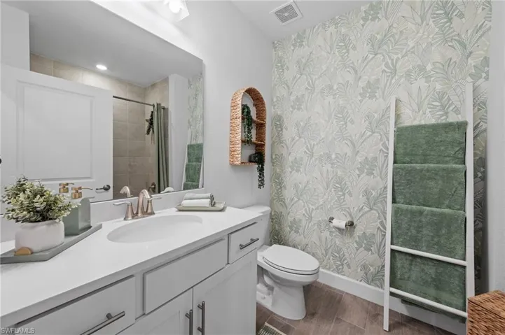 White vanity with an integrated sink, brushed nickel faucet, and under-cabinet storage