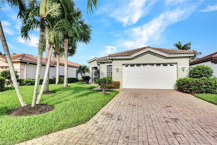 Mediterranean / spanish-style home with a garage and a front lawn