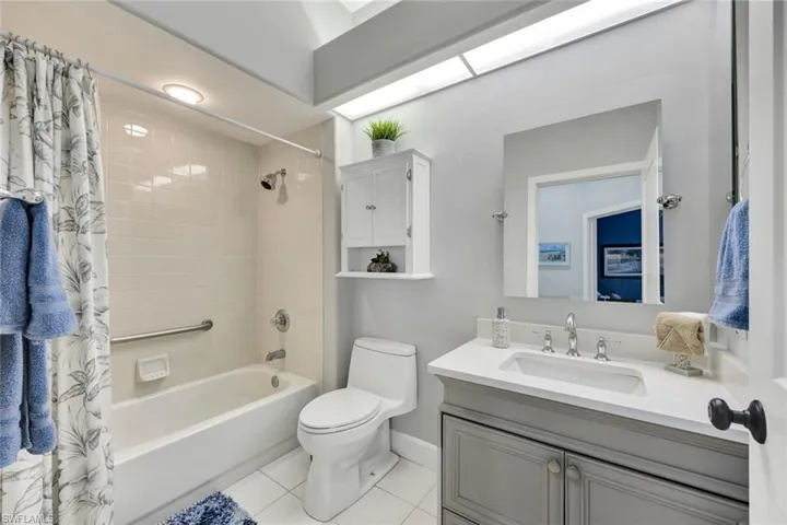 Full bathroom featuring tile flooring, toilet, vanity, and shower / bath combo
