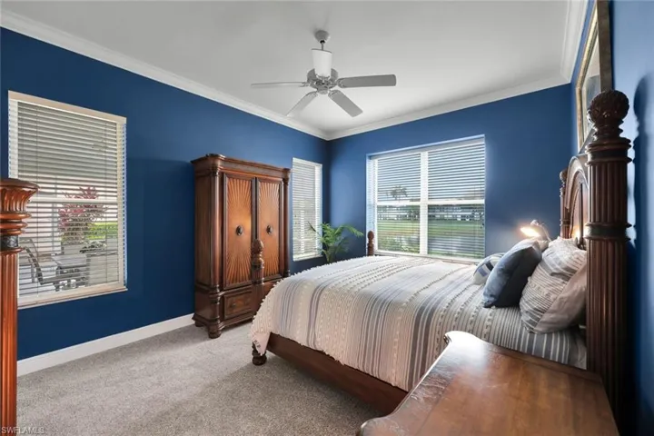 Bedroom with ceiling fan, carpet floors, and crown molding