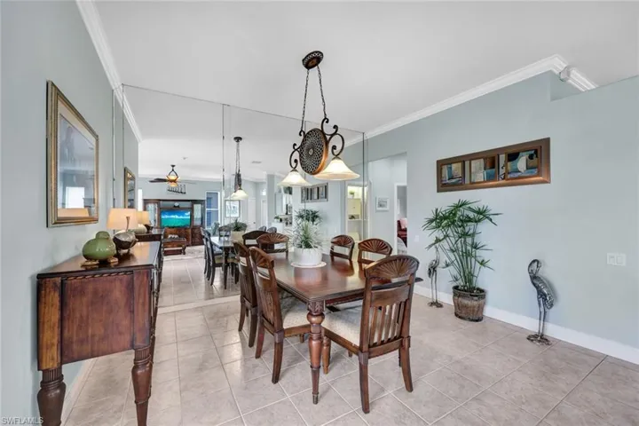 Tiled dining space with crown molding and ceiling fan