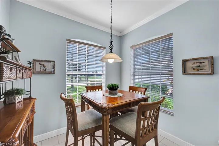 Tiled dining room featuring plenty of natural light and ornamental molding