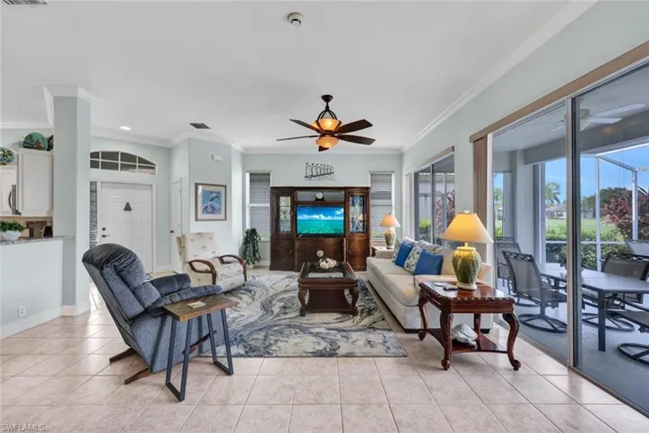 Tiled living room featuring ornamental molding and ceiling fan