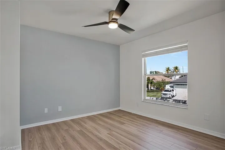 Empty room featuring light wood-type flooring and a ceiling fan