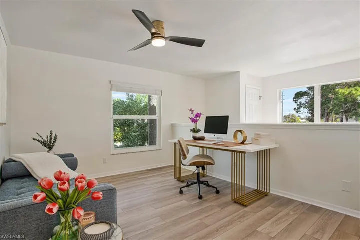 Office space with light wood finished floors and a ceiling fan