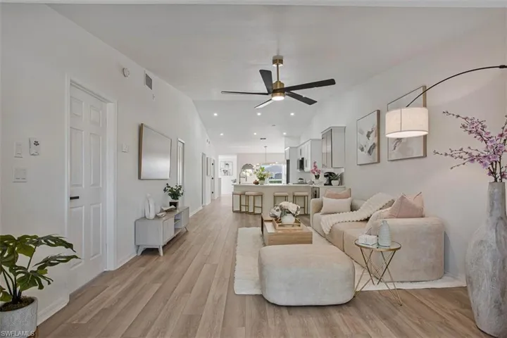 Living room featuring light wood finished floors, a ceiling fan, and recessed lighting