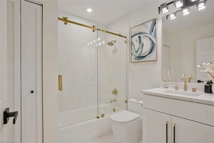 Bathroom with vanity and enclosed tub / shower combo