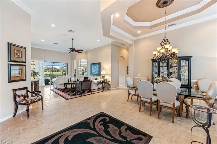 Dining space with crown molding and ceiling fan with notable chandelier
