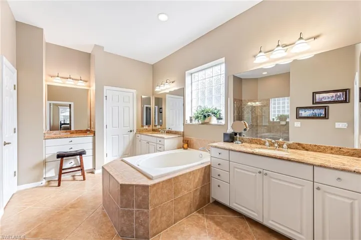 Bathroom with vanity, separate shower and tub, and tile patterned flooring