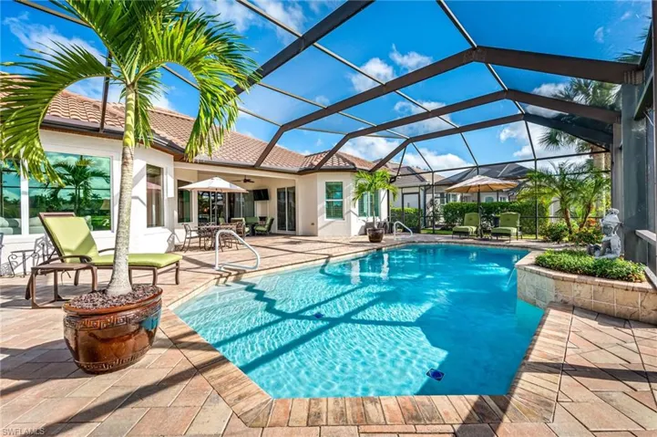 View of swimming pool with a patio and glass enclosure