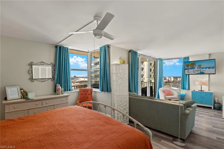 Bedroom featuring multiple windows, ceiling fan, and light hardwood / wood-style flooring