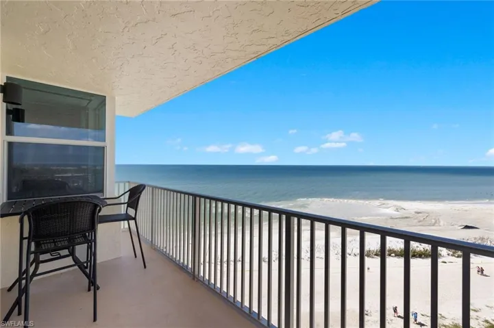 Balcony featuring a water view and a view of the beach