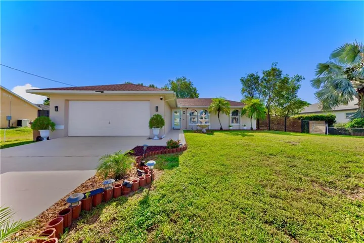Ranch-style house with a garage, concrete driveway, and stucco siding